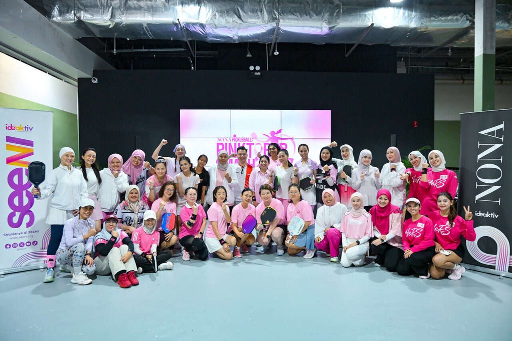 Gambar berkumpulan peserta dan selebriti yang mengenakan pakaian sukan merah jambu di acara NONA Pickleball Pinktober Smash