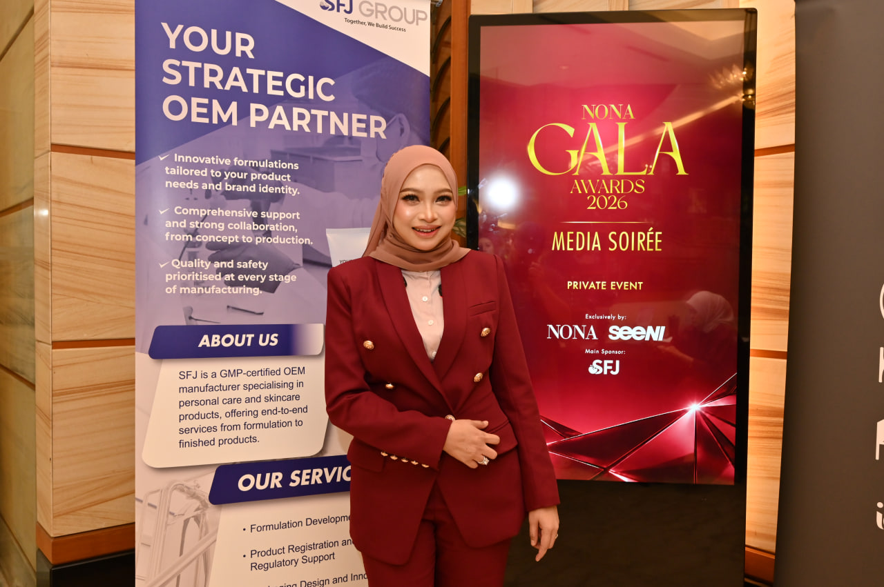 A guest posing in front of the SFJ Group sponsor banner and the NONA Gala Awards 2026 digital screen