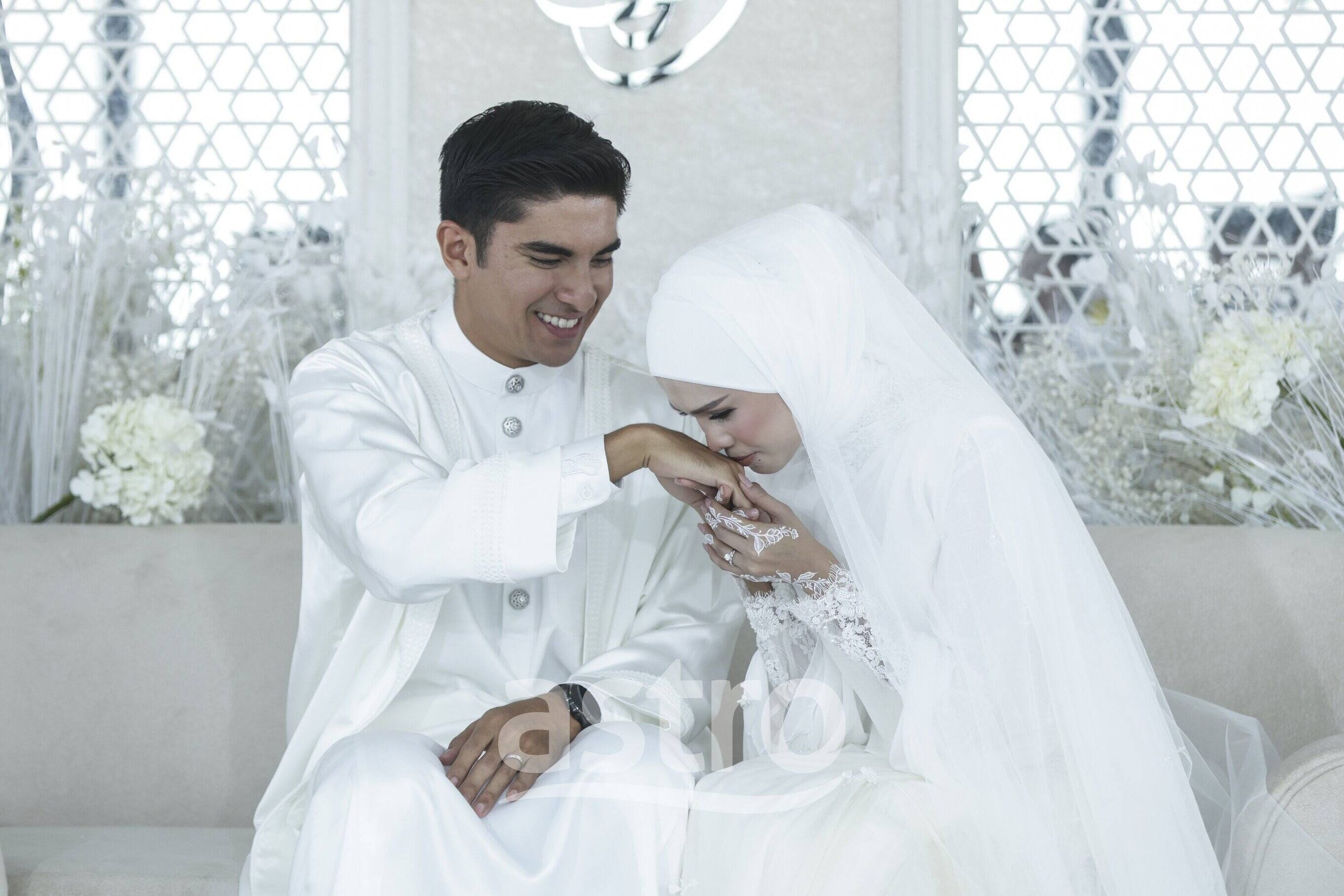Bella Astillah berbusana putih mencium tangan Syed Saddiq di atas pelamin sempena majlis akad nikah di Merdeka 118
